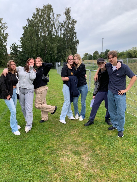 Sju elever som kramar varandra och tittar mot kameran.