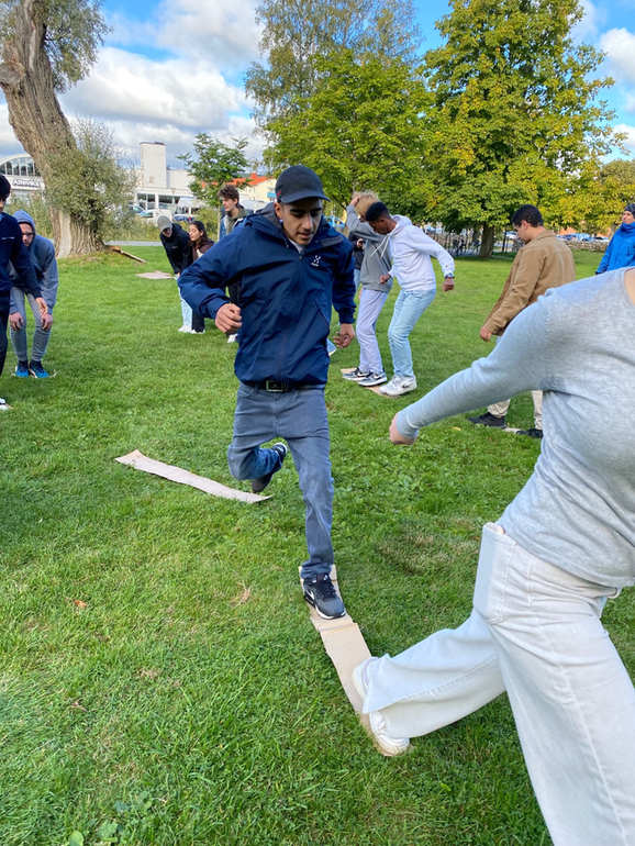 flera elever som går balansgång på plankor.