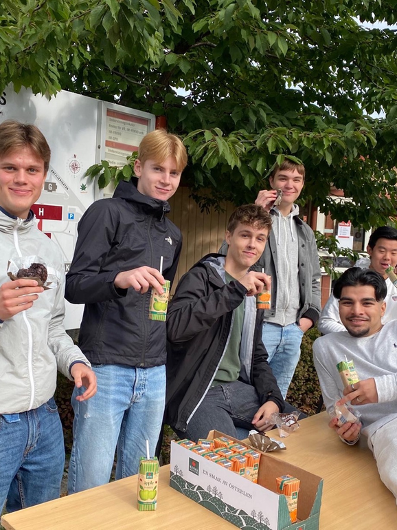 sex elever som tittar in i kameran och håller i juiceboxar.